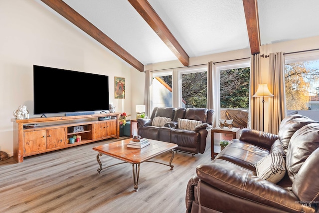 living room featuring vaulted ceiling with beams, plenty of natural light, and light hardwood / wood-style floors