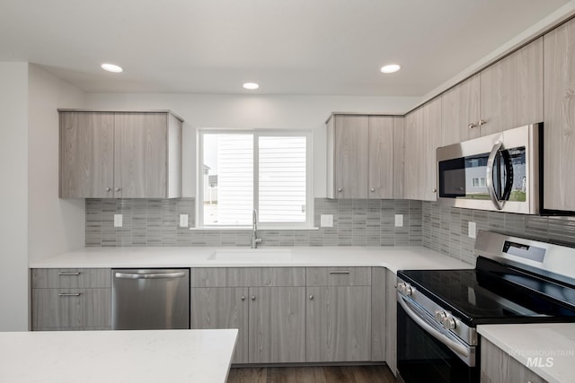 kitchen with a sink, light brown cabinets, stainless steel appliances, and light countertops