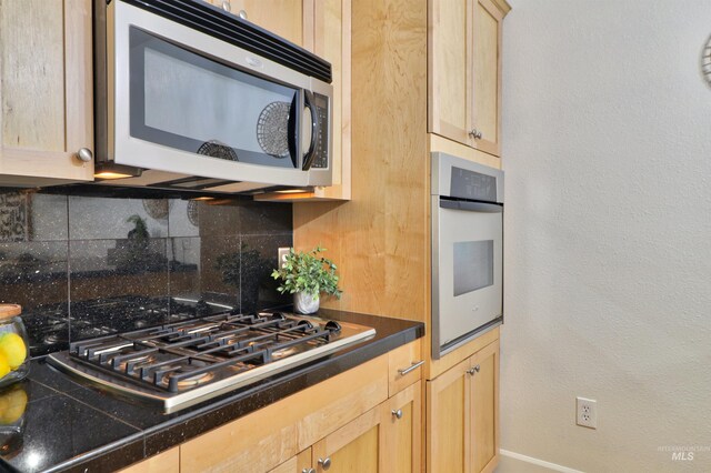 kitchen featuring light brown cabinets, backsplash, and appliances with stainless steel finishes