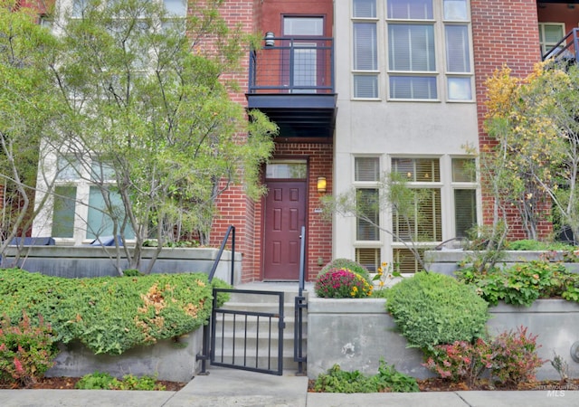 view of exterior entry with a balcony