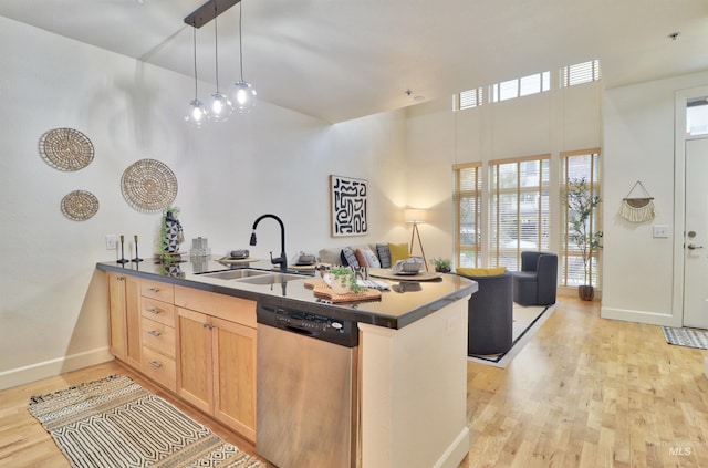 kitchen featuring stainless steel dishwasher, pendant lighting, kitchen peninsula, and sink