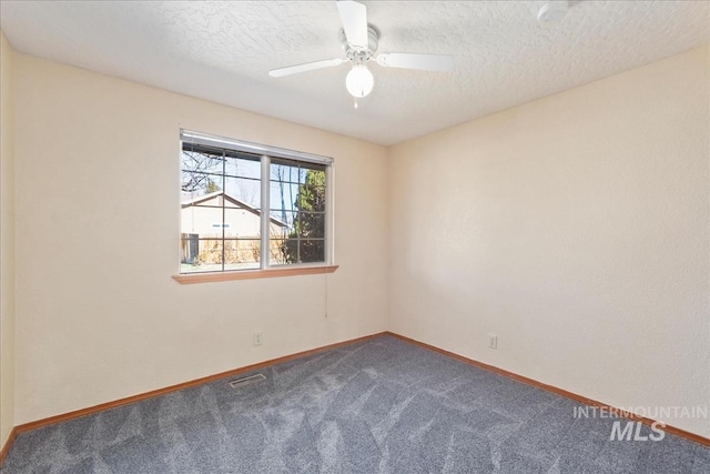 carpeted empty room featuring visible vents, ceiling fan, a textured ceiling, and baseboards