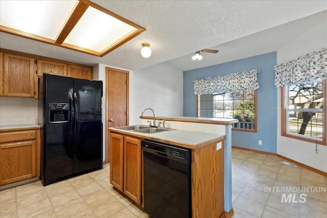 kitchen featuring black appliances, brown cabinets, visible vents, and a sink