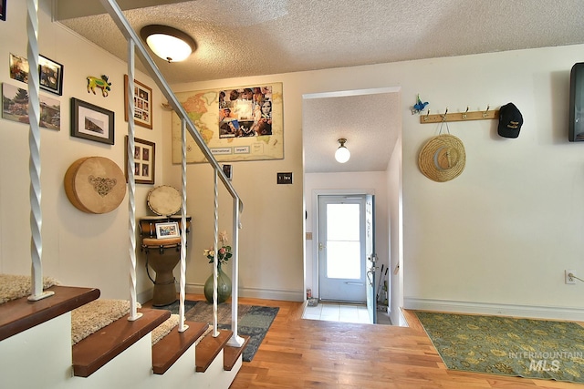 entrance foyer with wood-type flooring and a textured ceiling