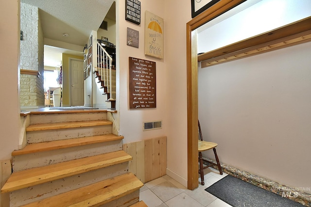 stairway with tile patterned flooring