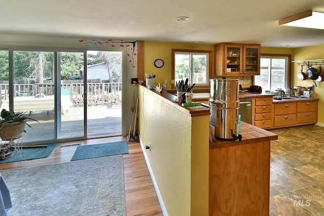 kitchen with dishwasher, tile counters, and kitchen peninsula