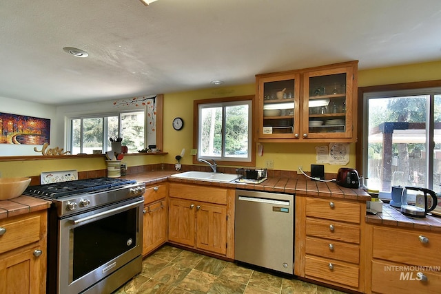 kitchen featuring sink, tile counters, and stainless steel appliances