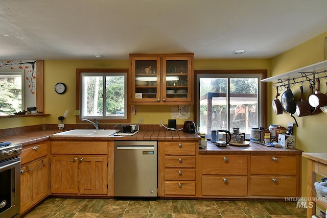 kitchen with sink, tile countertops, and appliances with stainless steel finishes