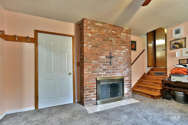 unfurnished living room featuring ceiling fan, light colored carpet, a fireplace, and a textured ceiling