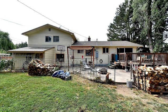 rear view of property with a wooden deck, an outdoor fire pit, a yard, and a patio area