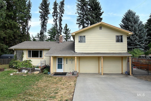 tri-level home featuring a garage and a front lawn