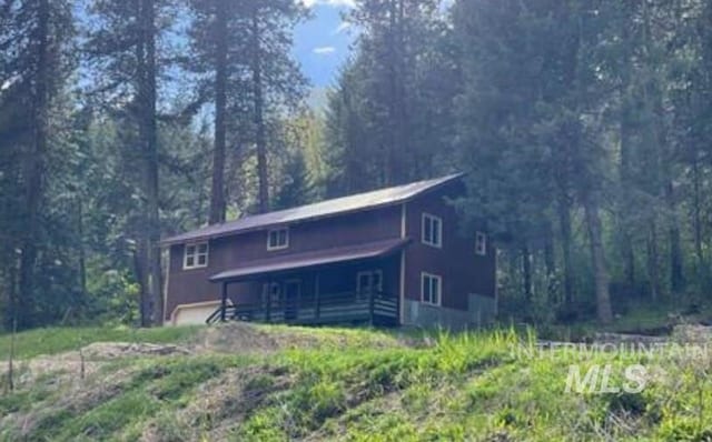 view of front facade with a wooded view