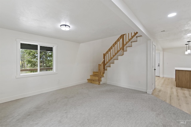 interior space with light carpet, baseboards, stairway, and recessed lighting