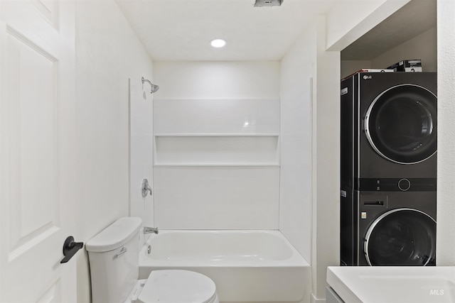 full bathroom featuring stacked washer / drying machine, bathtub / shower combination, vanity, and toilet