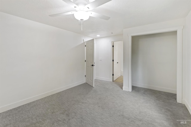 empty room featuring carpet floors, baseboards, and a ceiling fan