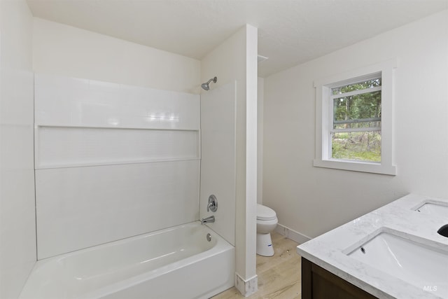 bathroom featuring shower / washtub combination, double vanity, toilet, a sink, and wood finished floors