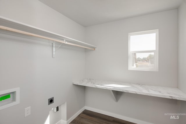 clothes washing area with dark wood-style floors, washer hookup, electric dryer hookup, laundry area, and baseboards