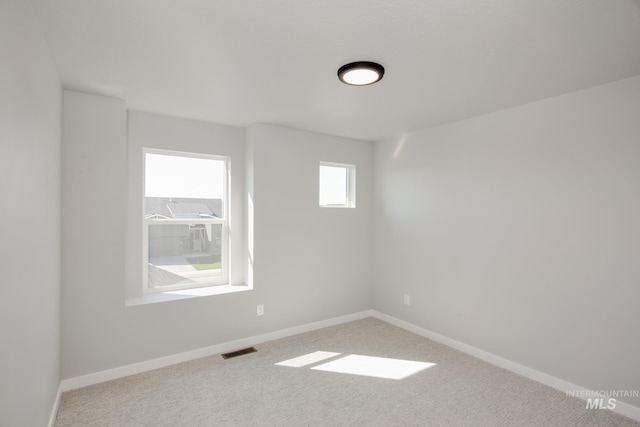 carpeted empty room with baseboards and visible vents