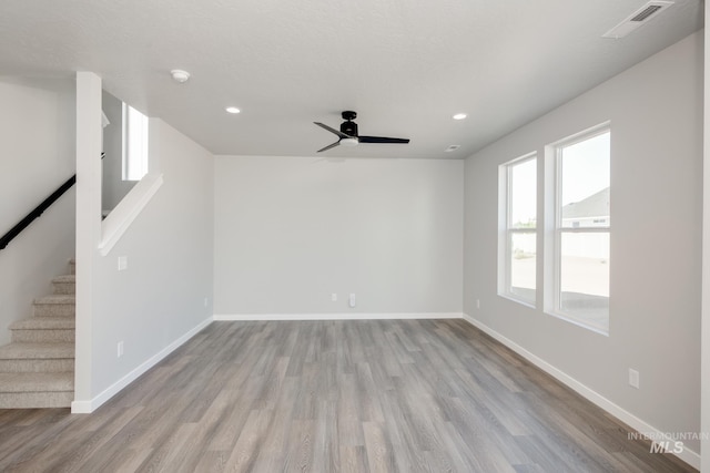 spare room with stairs, baseboards, wood finished floors, and recessed lighting