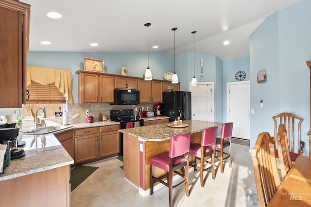 kitchen featuring a center island, black appliances, decorative backsplash, lofted ceiling, and a kitchen breakfast bar