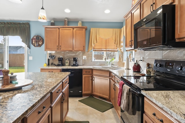 kitchen featuring sink, light stone counters, tasteful backsplash, black appliances, and pendant lighting