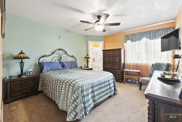 bedroom featuring ceiling fan, light colored carpet, and a textured ceiling