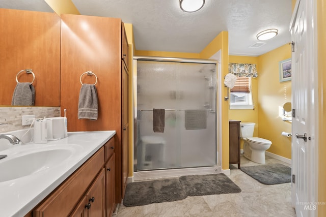 bathroom with a textured ceiling, vanity, a shower with shower door, and toilet