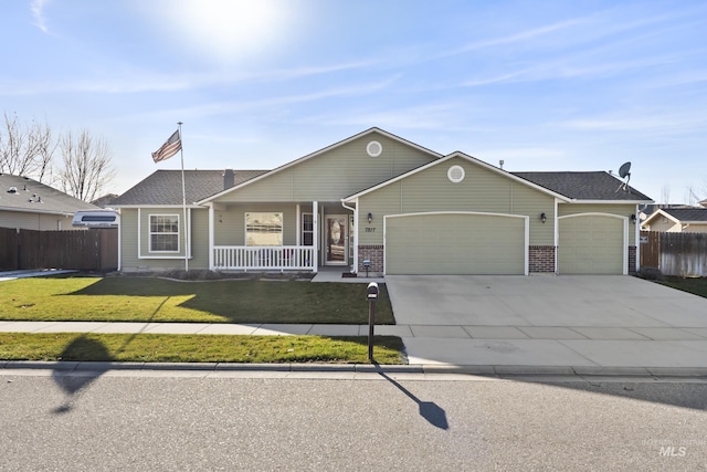 ranch-style house featuring covered porch, a front yard, and a garage