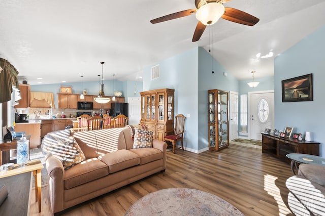 living room featuring sink, dark hardwood / wood-style flooring, ceiling fan, and vaulted ceiling