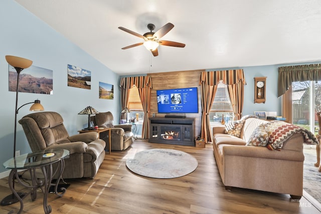 living room with lofted ceiling, hardwood / wood-style floors, and ceiling fan