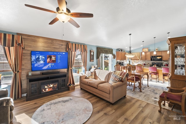 living room featuring plenty of natural light, ceiling fan, vaulted ceiling, and hardwood / wood-style floors