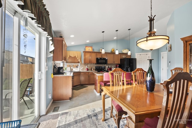 dining room with a healthy amount of sunlight, vaulted ceiling, and sink