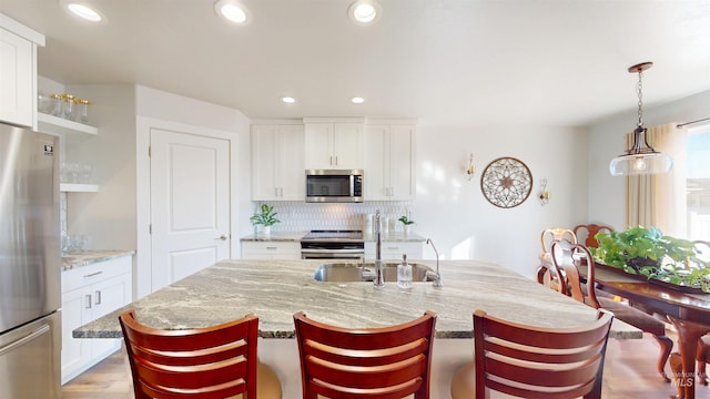 kitchen featuring decorative backsplash, recessed lighting, appliances with stainless steel finishes, and a breakfast bar