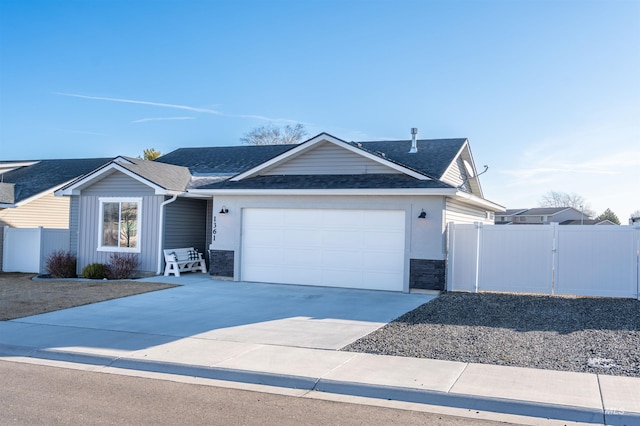 ranch-style house featuring a shingled roof, fence, concrete driveway, a garage, and a gate