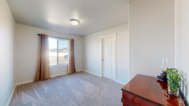 unfurnished bedroom featuring light carpet and baseboards