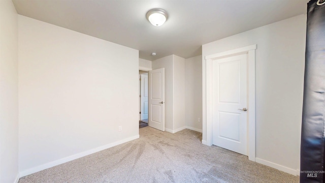 unfurnished bedroom with baseboards and carpet flooring