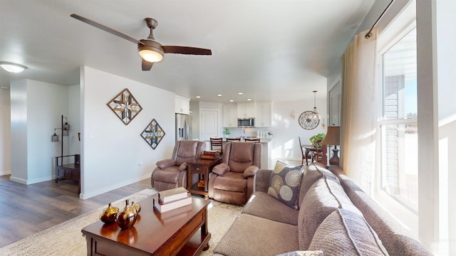 living room with recessed lighting, light wood-style flooring, a ceiling fan, and baseboards