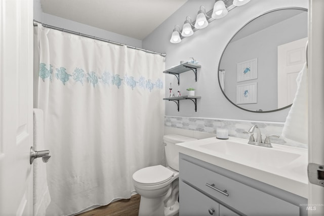 bathroom with tile walls, hardwood / wood-style floors, vanity, and toilet