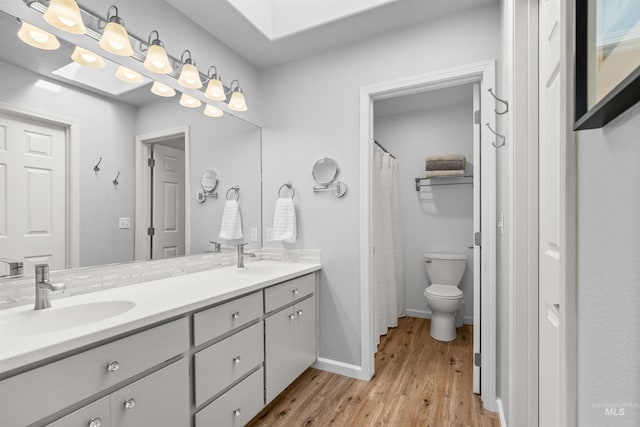 bathroom featuring toilet, hardwood / wood-style flooring, and vanity