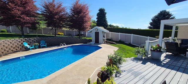 view of swimming pool featuring a deck and a shed