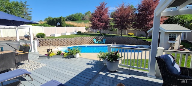 view of pool featuring a wooden deck and an outbuilding