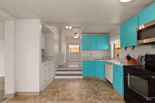 kitchen featuring black / electric stove, stainless steel microwave, white dishwasher, blue cabinets, and a textured ceiling