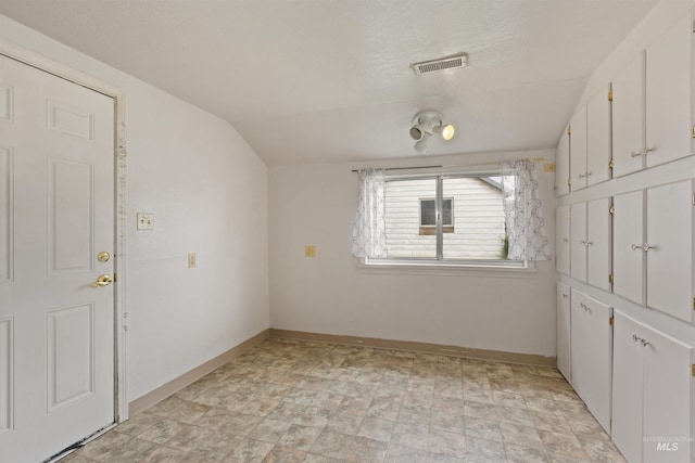 unfurnished bedroom featuring vaulted ceiling and baseboards