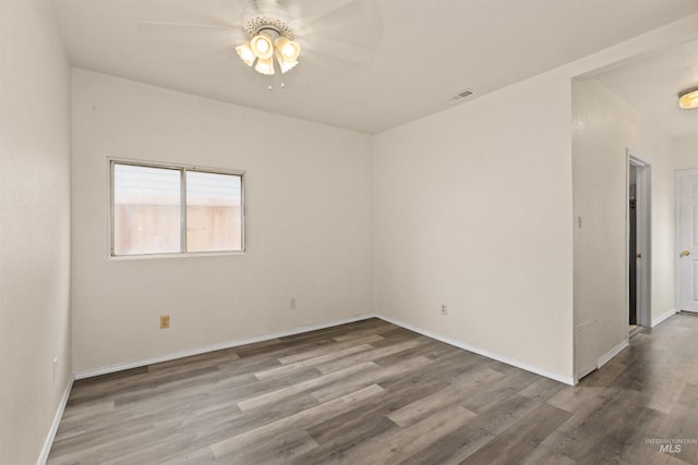 empty room featuring a ceiling fan, wood finished floors, and baseboards