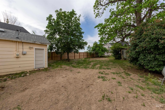 view of yard with fence and a garage