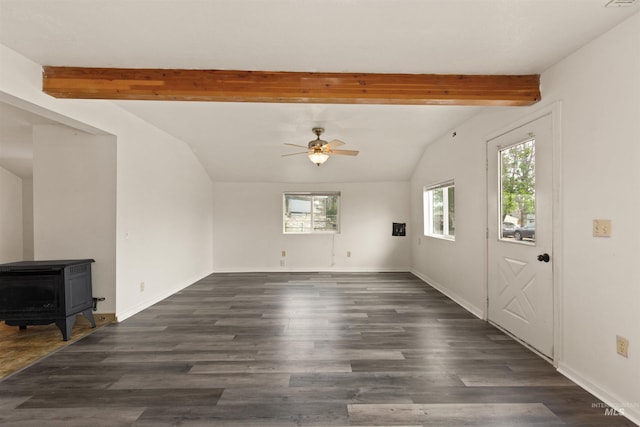 unfurnished living room featuring plenty of natural light, a ceiling fan, a wood stove, and dark wood-style flooring