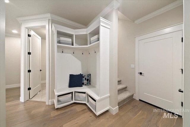 mudroom with ornamental molding and hardwood / wood-style flooring