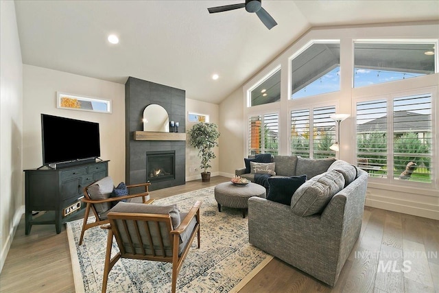 living room with light wood-type flooring, a wealth of natural light, and a fireplace