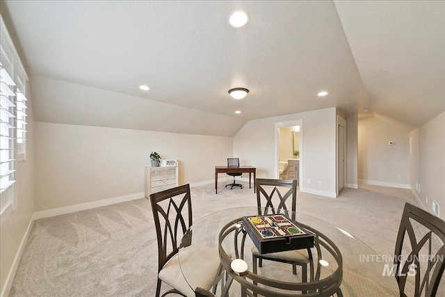 interior space featuring lofted ceiling, a textured ceiling, and light colored carpet