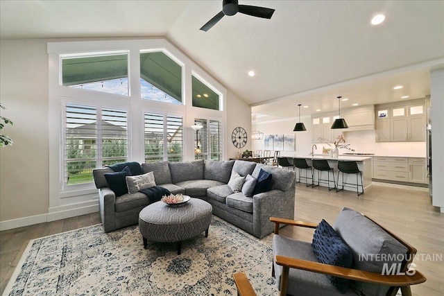 living room with lofted ceiling, sink, ceiling fan, and light hardwood / wood-style floors